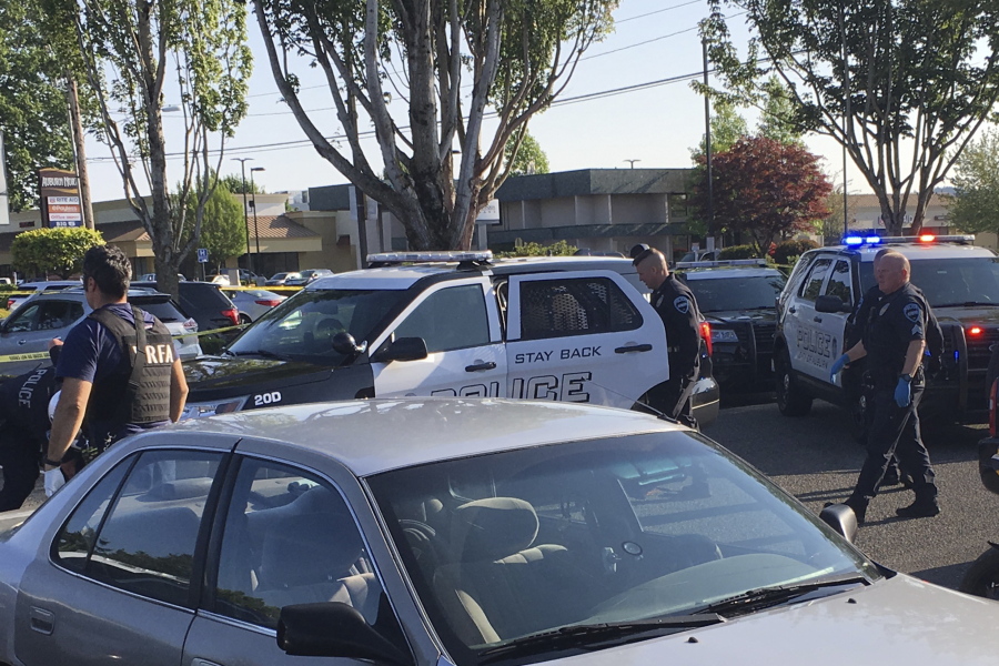 In this May 31, 2019, photo provided by the Auburn Police Department via the Port of Seattle Police Department, Auburn police Officer Jeff Nelson, second from right, is shown at the scene where he shot and killed Jesse Sarey in a grocery store parking lot in Auburn, Wash. Although Nelson has been investigated in more than 60 use-of-force cases since 2012, he wasn't placed on the King County Prosecuting Attorney's "potential impeachment disclosure" list, or Brady List, which flags officers whose credibility is in question due to misconduct, until after he was charged in Sarey's killing.