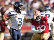Seattle Seahawks quarterback Russell Wilson (3) passes in front of San Francisco 49ers defensive tackle D.J. Jones during the second half of an NFL football game in Santa Clara, Calif., Sunday, Oct. 3, 2021.