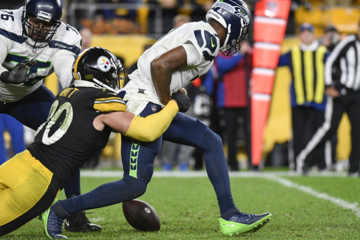 Seattle Seahawks quarterback Geno Smith (7) fumbles as Pittsburgh Steelers outside linebacker T.J. Watt (90) tackles him during overtime of an NFL football game, Sunday, Oct. 17, 2021, in Pittsburgh. The Steelers won 23-20 in overtime.