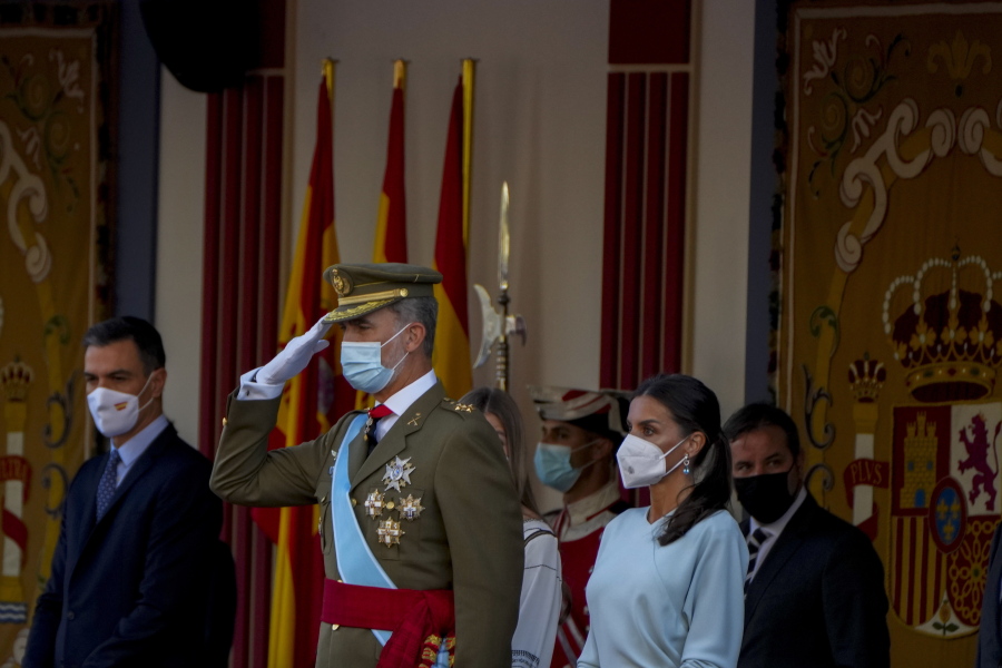 Spain's King Felipe, center, salutes next to Queen Letizia, right, during a military parade to celebrate a holiday known as 'Dia de la Hispanidad' or Hispanic Day in Madrid, Spain, Tuesday, Oct. 12, 2021. Spain commemorates Christopher Columbus' arrival in the New World and also Spain's armed forces day.