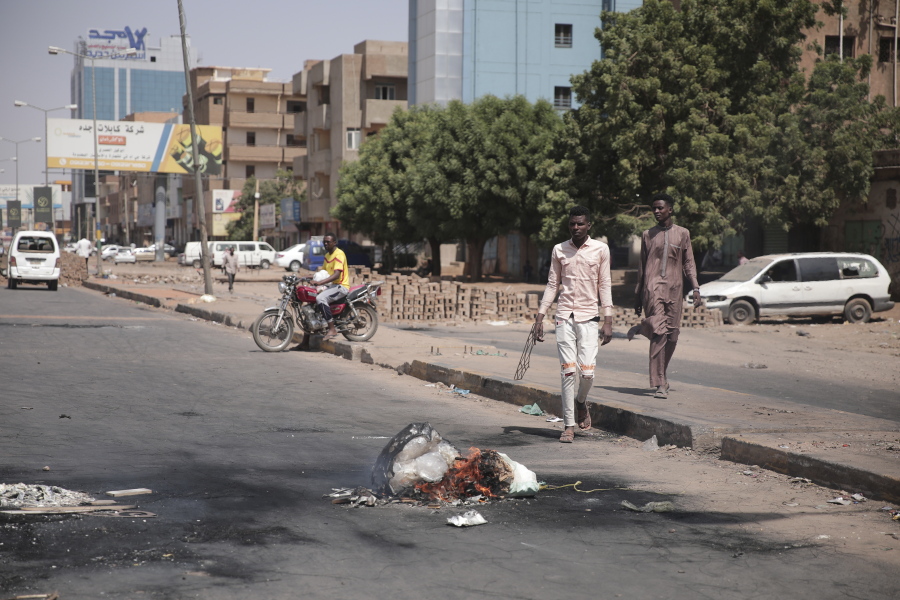 People walk on a street in Khartoum, Sudan, two days after a military coup, Wednesday, Oct. 27, 2021. The coup threatens to halt Sudan's fitful transition to democracy, which began after the 2019 ouster of long-time ruler Omar al-Bashir and his Islamist government in a popular uprising. It came after weeks of mounting tensions between military and civilian leaders over the course and pace of that process.
