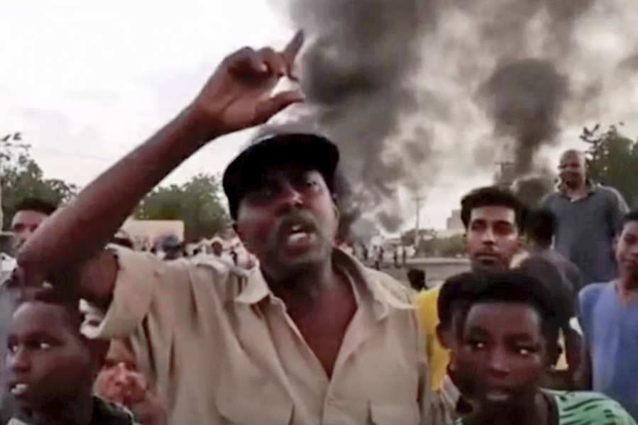 In this frame taken from video people gather during a protest in Khartoum, Sudan, Monday, Oct. 25, 2021. Military forces arrested Sudan's acting prime minister and senior government officials Monday, disrupted internet access and blocked bridges in the capital Khartoum, the country's information ministry said, describing the actions as a coup. In response, thousands flooded the streets of Khartoum and its twin city of Omdurman to protest the apparent military takeover. Footage shared online appeared to show protesters blocking streets and setting fire to tires as security forces used tear gas to disperse them.