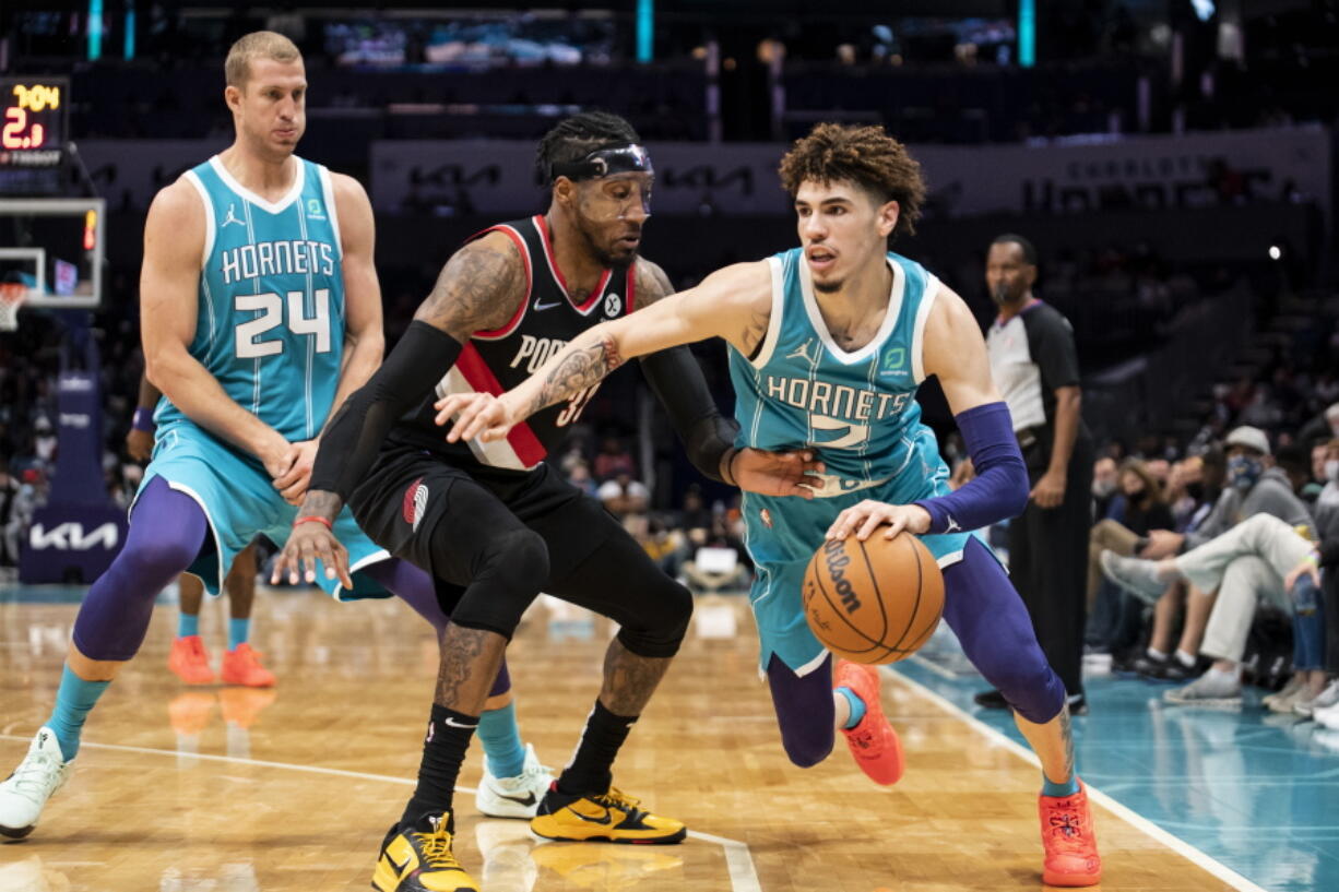 Charlotte Hornets guard LaMelo Ball (2) drives around Portland Trail Blazers forward Robert Covington (33) after Hornets center Mason Plumlee (24) set a screen during the first half of an NBA basketball game, Sunday, Oct. 31, 2021, in Charlotte, N.C.
