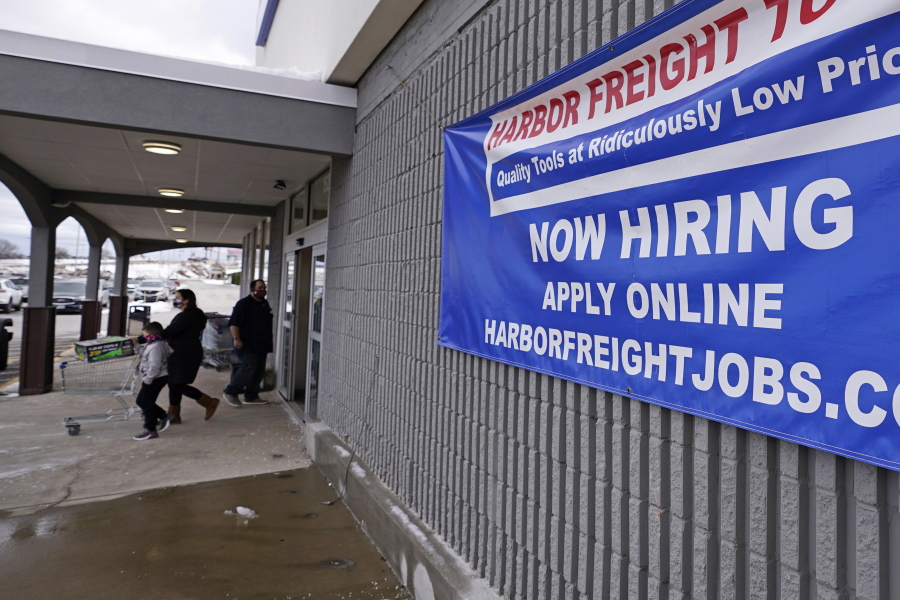 FILE - In this Dec. 10, 2020, file photo, a "Now Hiring" sign hangs on the front wall of a Harbor Freight Tools store in Manchester, N.H. When the U.S. government issues the September jobs report on Friday, Oct. 8, 2021, the spotlight will fall not only on how many people were hired last month. A second question will command attention, too: Are more people finally starting to look for work?