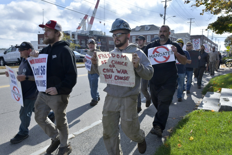 Justin Paetow, center, a tin shop worker at Bath Iron Works, takes part in a demonstration against COVID-19 vaccine mandate outside the shipyard on Friday, Oct. 22, 2021, in Bath, Maine.