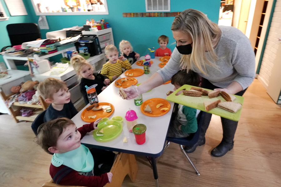 Amy McCoy serves lunch to preschoolers at her Forever Young Daycare facility, Monday, Oct. 25, 2021, in Mountlake Terrace, Wash. Child care centers once operated under the promise that it would always be there when parents have to work. Now, each teacher resignation, coronavirus exposure, and day care center closure reveals an industry on the brink, with wide-reaching implications for an entire economy's workforce.