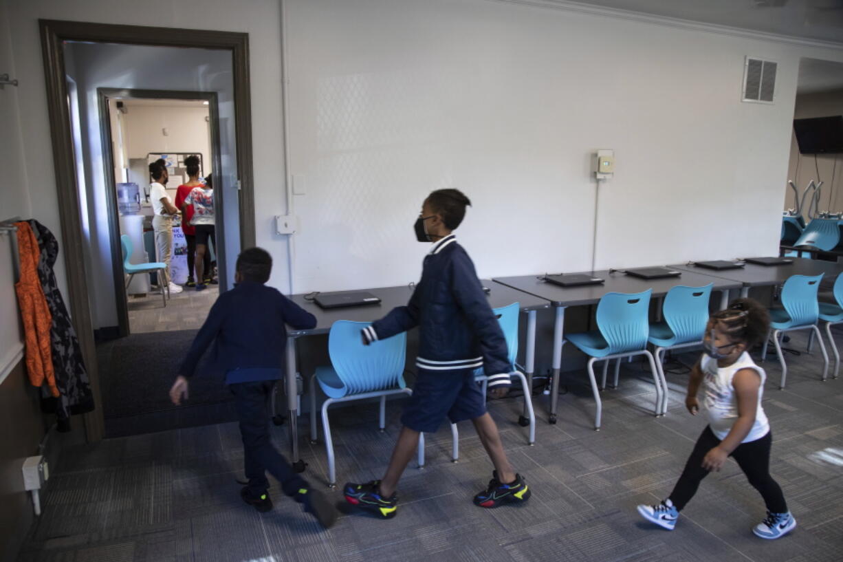 Zihare Wellons, 7, from left, Shahif Wellons, 12, and Janiyah Acie, 3,  walk Friday through new Rec2Tech space at Jefferson Recreation Center, which will provide access to technology and innovative programming for community members in Pittsburgh. The city plans to use some of the money from the American Rescue Plan to continue expanding these programs.