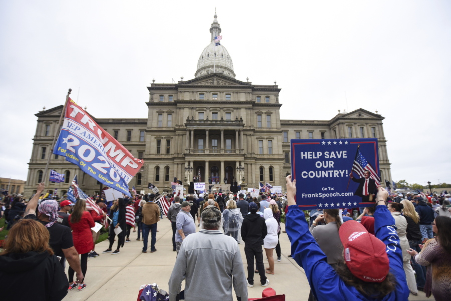 FILE - In this Oct. 12, 2021 file photo, rally-goers protest at the Michigan State Capitol in Lansing, Mich.   Republicans have had wild success this year passing voting restrictions in states they control politically, from Georgia to Iowa to Texas.