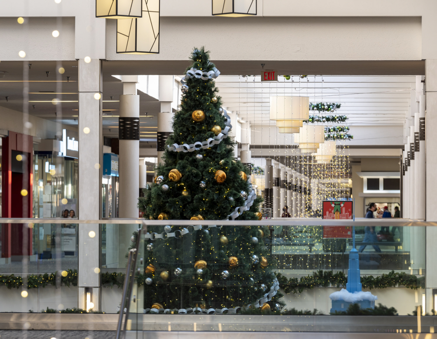 A two-story Christmas tree sits among hanging holiday lights at Vancouver Mall, which is already in Christmas mode. The mall is also at near peak capacity with tenants after eight new stores opened in eight weeks. Retailers are expecting a busier than average year, especially with no indoor capacity limits.