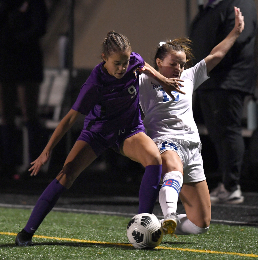 Ridgefield senior Paytn Barnette, right, and Columbia River sophomore Avah Eslinger fight for the ball Tuesday, Nov. 2, 2021, during the Spudders' 3-0 win against Columbia River in a GSHL District 4 2A playoff game at Columbia River High School.