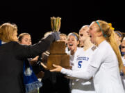 Hockinson athletic director Kathy Pacheco presents Ridgefield with the district championship trophy in the 2A District Girls Soccer Championship on Thursday, Nov. 4, 2021, at District Stadium in Battle Ground.