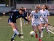Hockinson's Ellie Ritter delivers a cross as Ridgefield's Ava Kruckenberg defends in the 2A District Girls Soccer Championship on Thursday, Nov. 4, 2021, at District Stadium in Battle Ground.