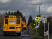 A school bus passes a speed limit sign near the intersection of Northeast 18th Street and 172nd Avenue on Friday afternoon.