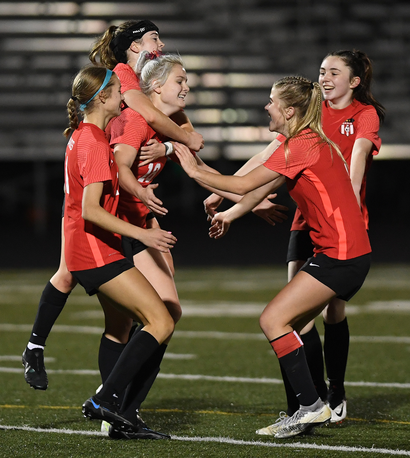Teammates swarm Camas senior Emerson Grafton, third from left, after a goal Wednesday, Nov. 10, 2021, during the Papermakers' 2-0 win against Kennedy Catholic in the first round of the 4A state tournament at Doc Harris Stadium in Camas.