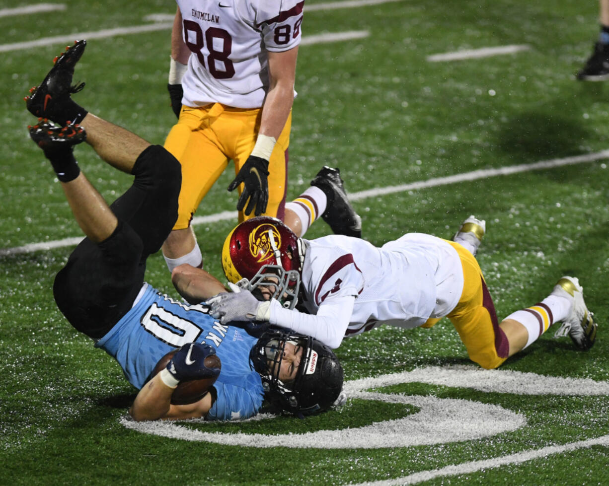 Hockinson junior John Charles, left, flips over after a reception against Enumclaw in the first round of the 2A state playoffs Friday at Battle Ground.