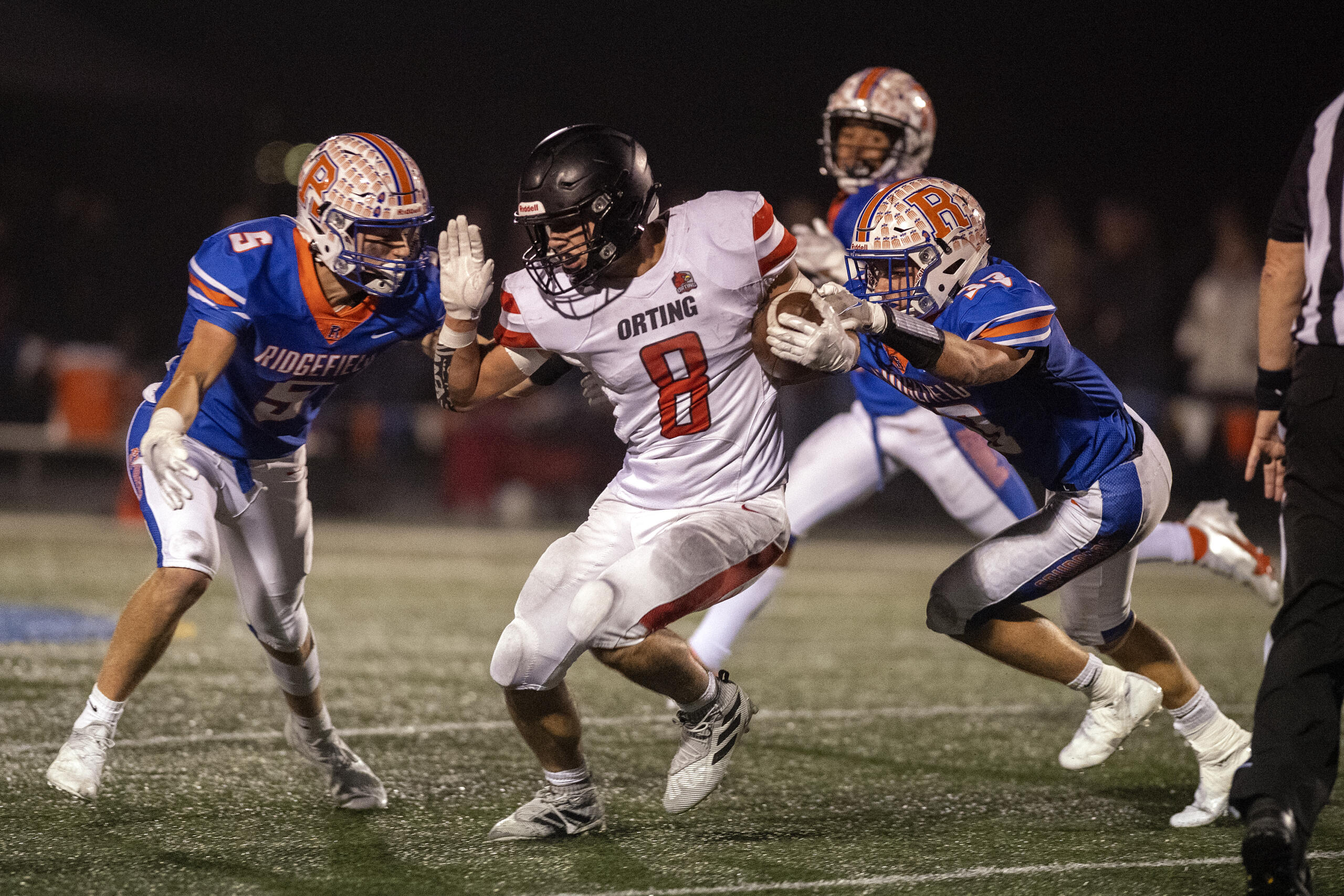 Ridgefield's Ty Snider (5) defends against Orting's Aiden Herd (8) while assisted by teammate Davis Pankow (33) in the second quarter At Ridgefield High School on Saturday night, Nov. 13, 2021.