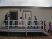 Substitute teacher Alison Davies, left, holds the door while leading second-graders back to their classroom at Union Ridge Elementary School on Wednesday afternoon. A rapid increase in the student population has forced schools in Ridgefield to create additional classroom spaces, like the one seen above.