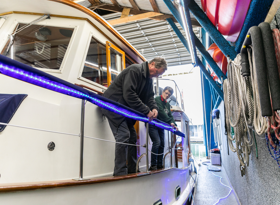 Pete and Kat Pettersen decorate their boat, the Points North III, with lights in preparation for upcoming Christmas Ships parades. The Pettersens' street address is near Longview, but they often live aboard their boat and boathouse at the Tyee Yacht Club in Portland.