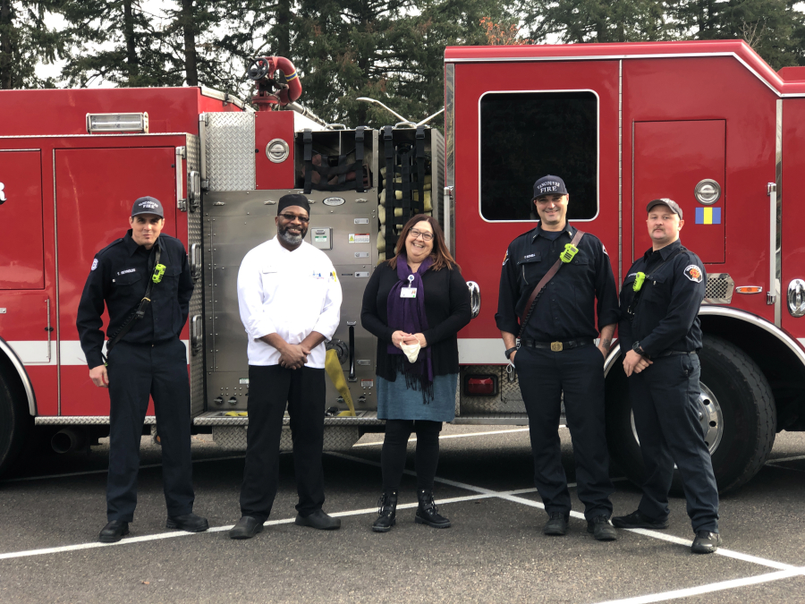 From left: Firefighter-paramedic Tucker Reynolds, chef Earl Frederick, Hope Bereavement Hospice Outreach Supervisor Colleen Storey, Fire Capt. Tom Schell and firefighter Andrey Yelizavetskiy pose for a photo Monday outside of Clark College shortly after cooking meals for 17 hospice families.
