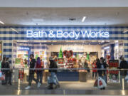 Black Friday shoppers pass in front of customers waiting in line at Bath and Body Works on Friday at the Vancouver Mall. Black Friday seemed to return to its pre-pandemic level as the parking lot filled and store owners had busier crowds return with no building capacity limits.