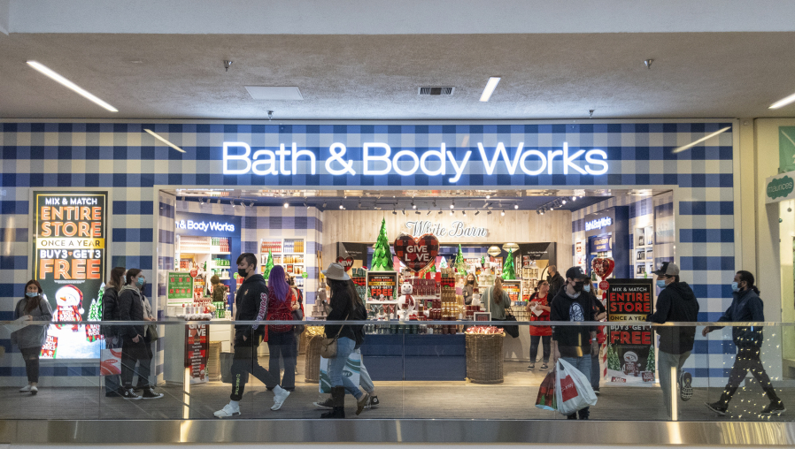 Black Friday shoppers pass in front of customers waiting in line at Bath and Body Works on Friday at the Vancouver Mall. Black Friday seemed to return to its pre-pandemic level as the parking lot filled and store owners had busier crowds return with no building capacity limits.