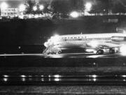 In the Associated Press file photos at top, the hijacked Northwest Airlines jetliner sits on a runway for refueling on Nov. 25, 1971, at Seattle-Tacoma International Airport. The Boeing 727 eventually flew south carrying skyjacker D.B. Cooper and a minimal crew.
