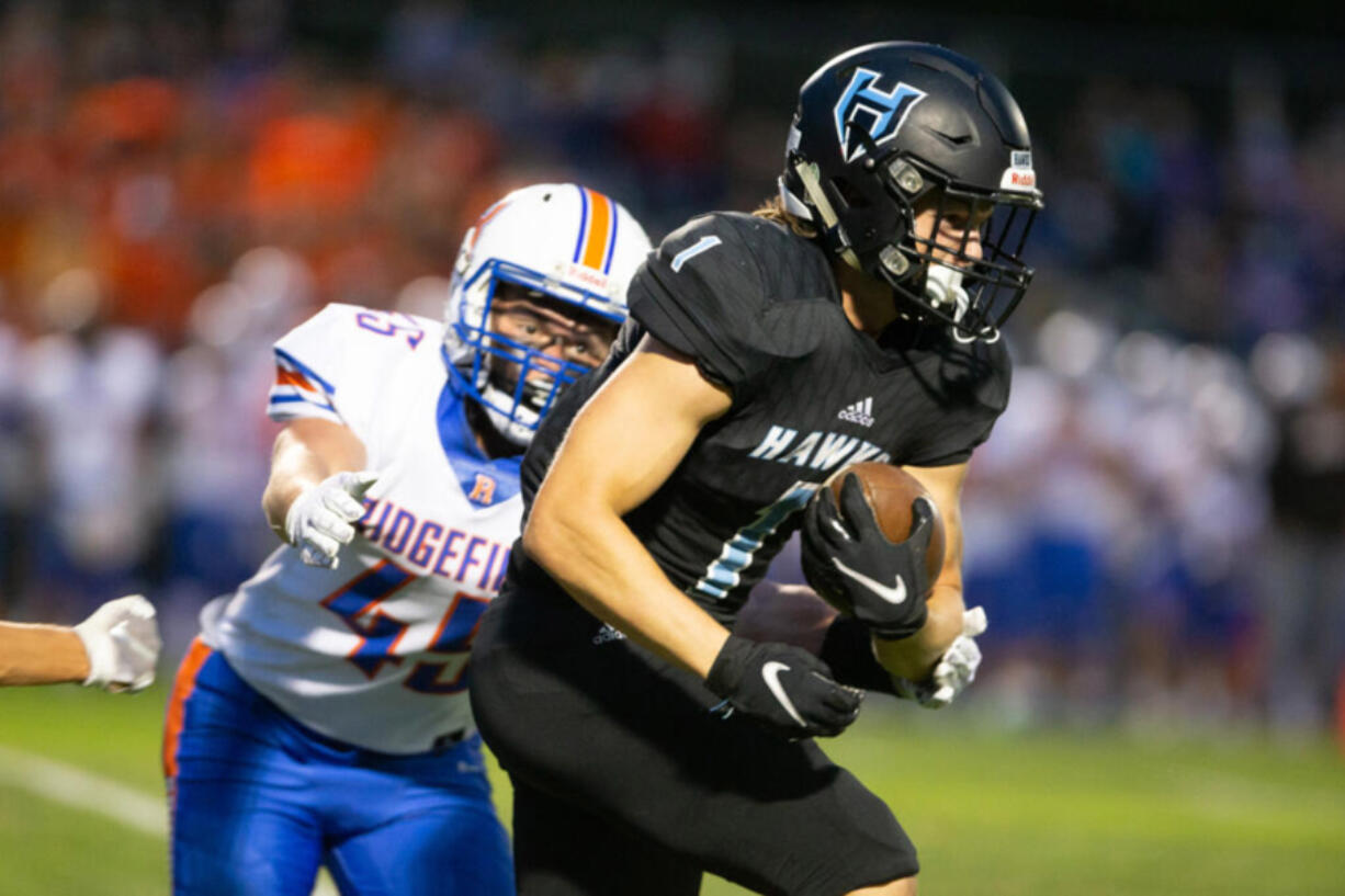 Hockinson Hawks Andre Northrup (1) gains against Ridgefield Spudders Connor Delamarter (45) in the 2A Greater St. Helens League season opener for both teams at Hockinson High School on Friday, Sept. 17, 2021. (Randy L.