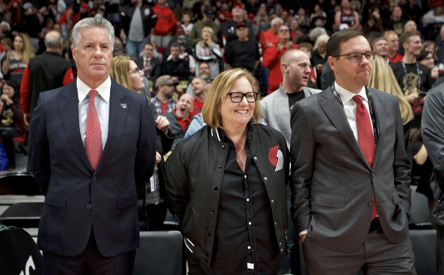 Portland Trail Blazers owner Jody Allen, center, with general manager Neil Olshey, left, and president Chris McGowan, right, at a game in 2019. McGowan stepped down from his position on Friday, November 12, 2021, after nine years in the position.