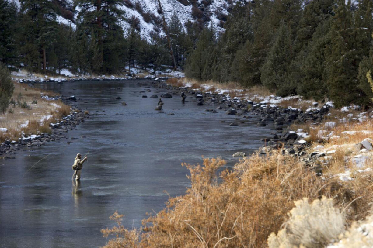 An angler makes a cast while fishing the Crooked River below the Bowman Dam.