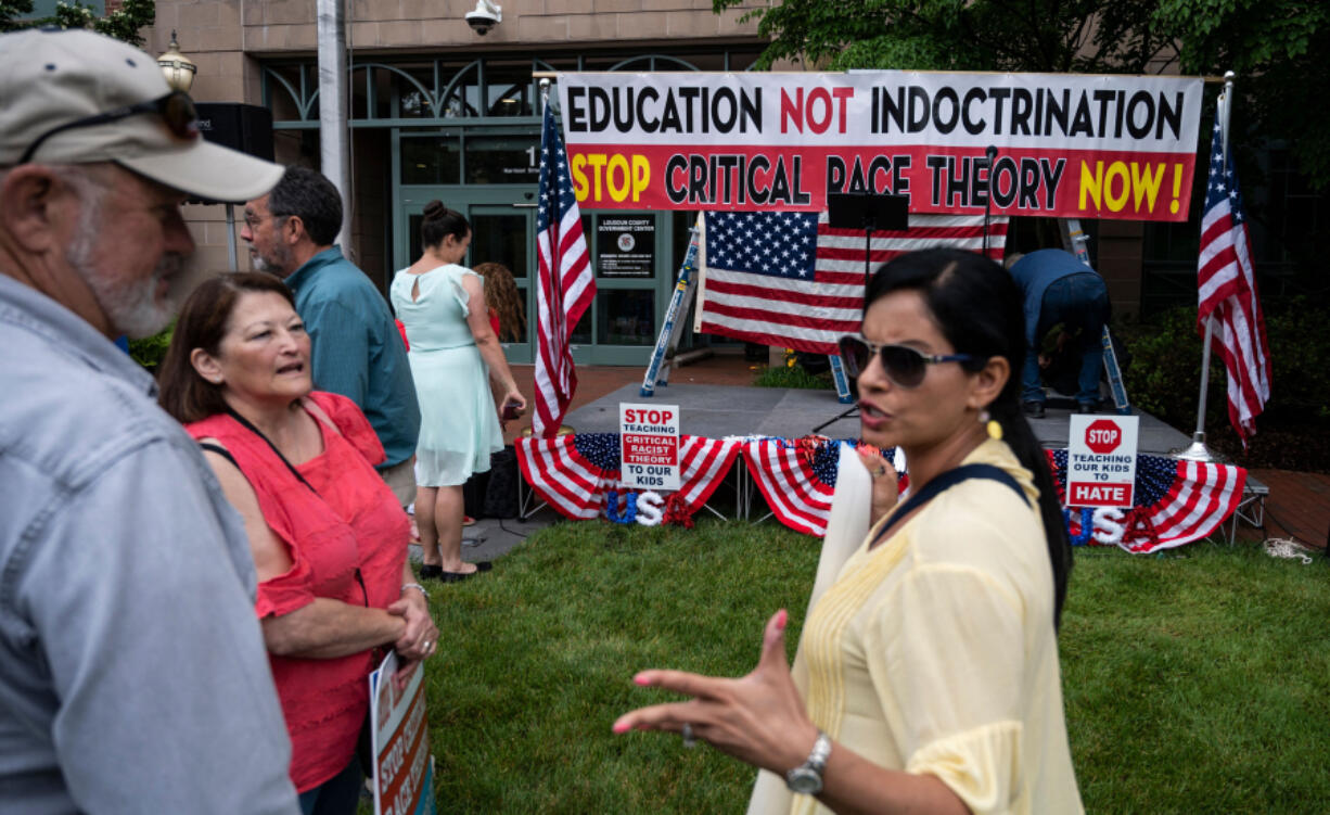 People talk before the start of a rally against "critical race theory" being taught in schools at the Loudoun County Government center in Leesburg, Virginia, in June. Some parents in Texas who say they are concerned about "critical race theory" have successfully petitioned their local school districts to remove certain books from their libraries.
