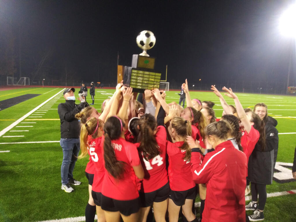 The Camas girls soccer team hoists the championship trophy after beating Issaquah 1-0 in overtime on penalty kicks on Saturday, Nov.