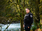 Officer Francis Reagan stands on the bank of the Washougal River where he saved a woman from drowning in May 2019. Reagan, who received the state's Law Enforcement Medal of Honor for the rescue, helped a Portland woman hold her head out of the frigid water for about 45 minutes in total. (Molly J.