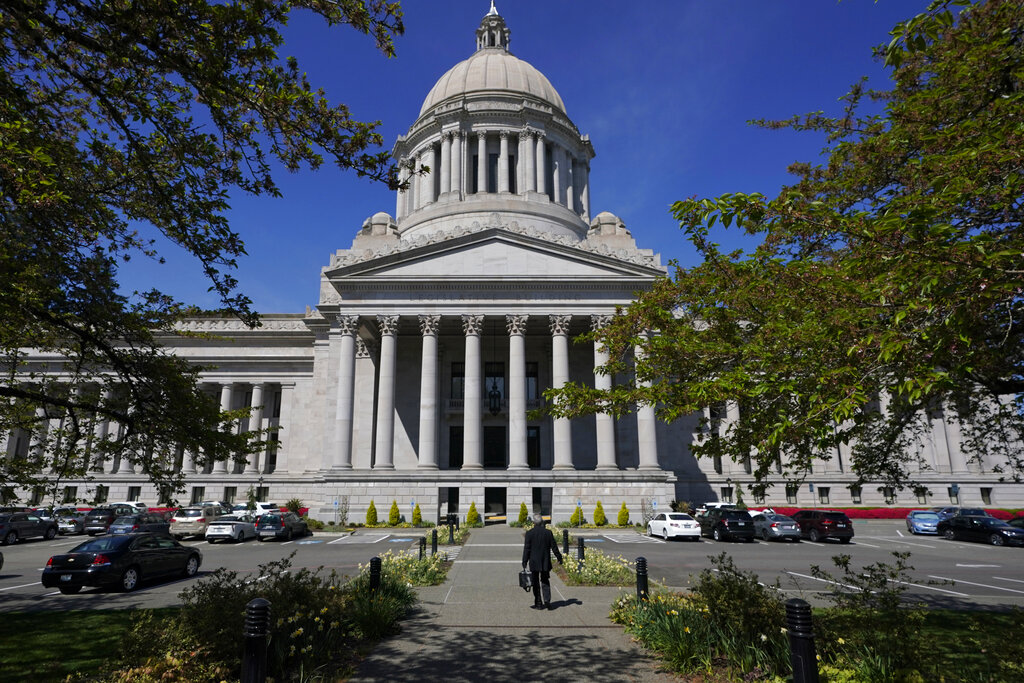 A person walks near the Legislative Building, Wednesday, April 21, 2021, at the Capitol in Olympia.  (AP Photo/Ted S.