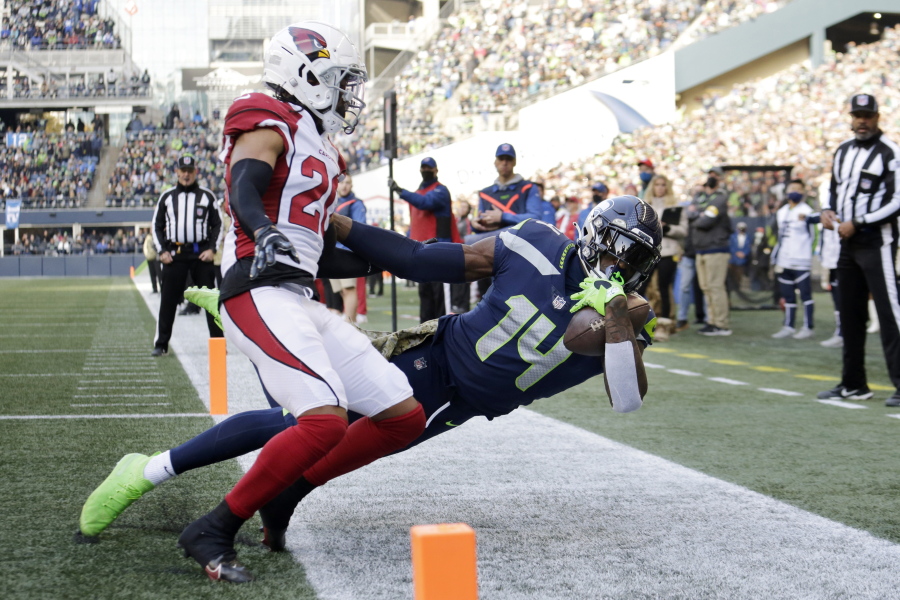 Seattle Seahawks wide receiver DK Metcalf (14) holds onto the ball for a catch but is ruled out of bounds as Arizona Cardinals' Marco Wilson defends during the first half of an NFL football game, Sunday, Nov. 21, 2021, in Seattle.