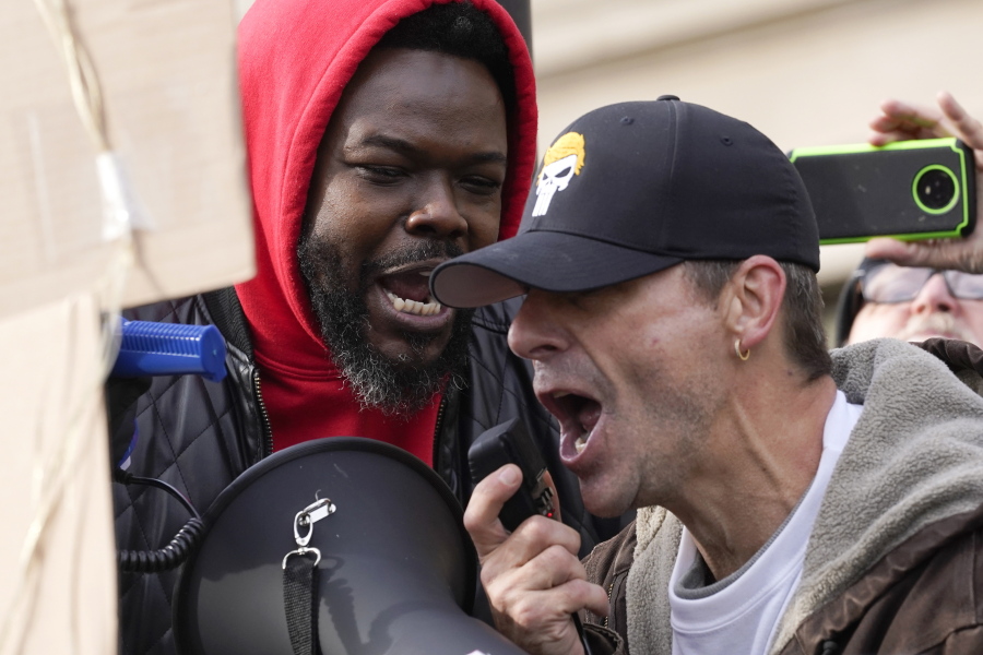 Protesters confront each other outside the Kenosha County Courthouse, Tuesday, Nov. 16, 2021, in Kenosha, Wis., during the Kyle Rittenhouse murder trial. Rittenhouse is accused of killing two people and wounding a third during a protest over police brutality in Kenosha, last year.