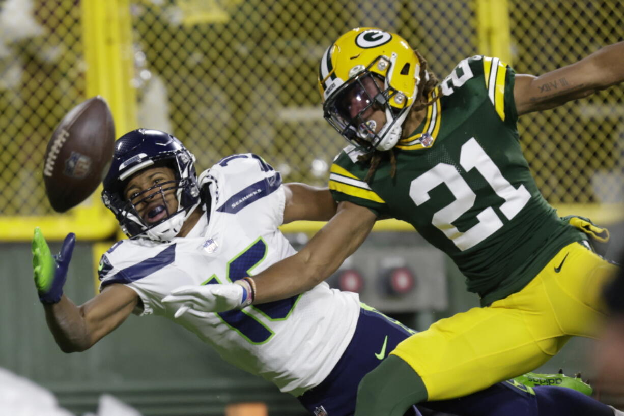 Green Bay Packers' Eric Stokes breaks up a pass intended for Seattle Seahawks' Tyler Lockett during the first half of an NFL football game Sunday, Nov. 14, 2021, in Green Bay, Wis.