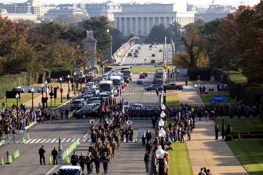 Troops march during a full honors procession honoring the centennial anniversary of the Tomb of the Unknown Soldier, Thursday, Nov. 11, 2021 at Arlington National Cemetery in Arlington, Va. The Lincoln Memorial in Washington is shown in the distance.