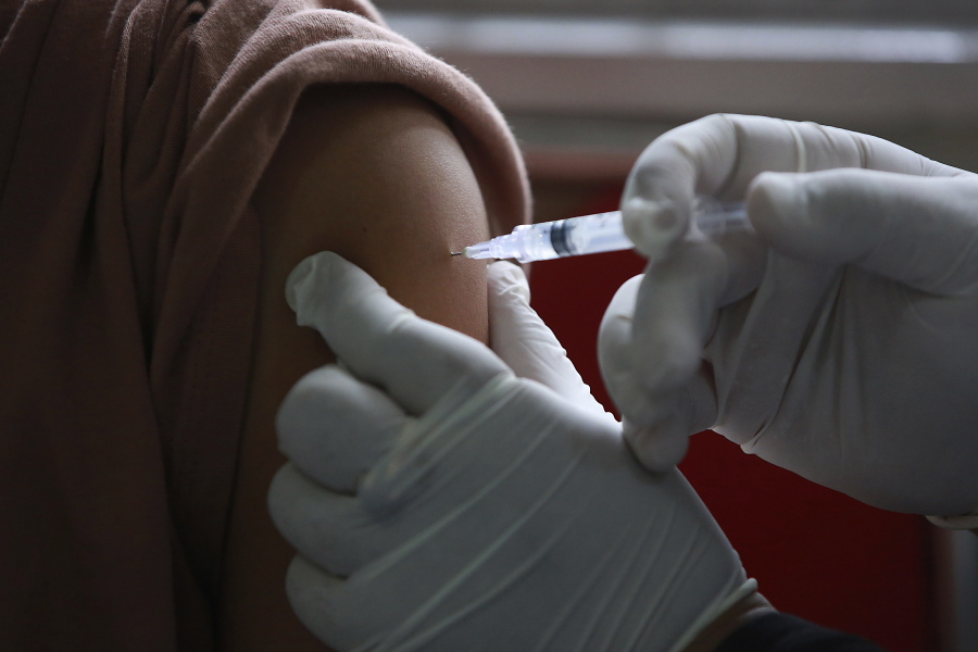A health worker gives a shot of the Pfizer COVID-19 vaccine to a man during a vaccination campaign at a community health center in Medan, North Sumatra, Indonesia, Wednesday, Nov. 17, 2021.