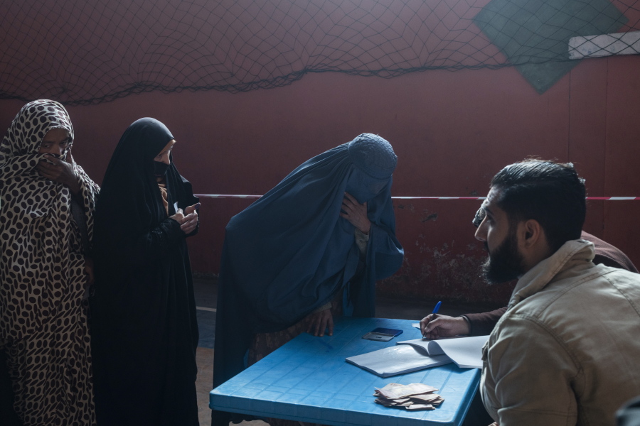 An Afghan woman resisters her name to receive cash at a money distribution center, organized by the World Food Program in Kabul, Afghanistan on Wednesday, Nov. 17, 2021. With the U.N. warning millions are in near-famine conditions, the WFP has dramatically ramped up direct aid to families.