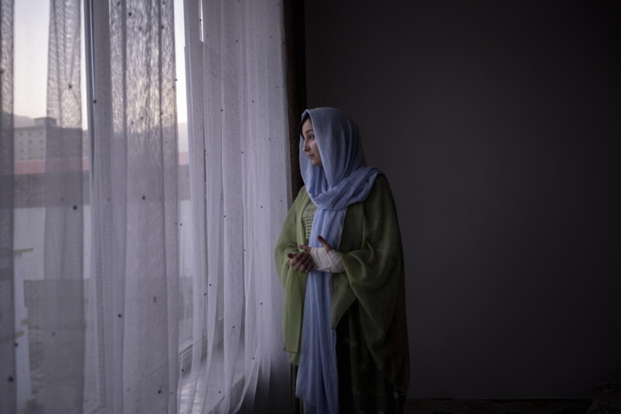 Rishmin Juyanda looks out of the window in Kabul, Afghanistan, Friday, Oct. 22, 2021.  A rights activist, she is part of an underground network determined to fight repressive Taliban policies that limit the freedoms of women.