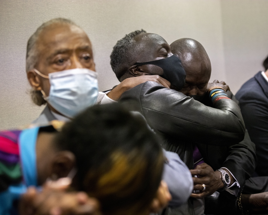 Ahmaud Arbery's father Marcus Arbery, center, his hugged by his attorney Benjamin Crump after the jury convicted Travis McMichael in the Glynn County Courthouse, Wednesday, Nov. 24, 2021, in Brunswick, Ga. (AP Photo/Stephen B.