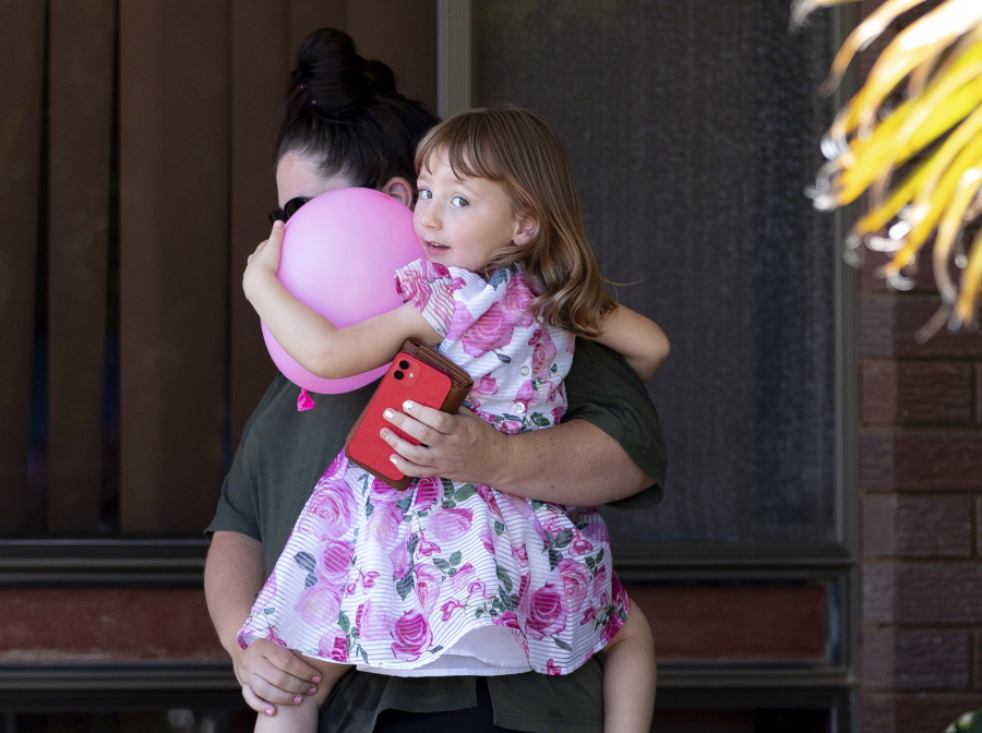 Cleo Smith, right, and her mother Ellie Smith leave a house where they spent the night after 4-year-old Cleo was rescued in Carnarvon, Australia, Thursday, Nov. 4, 2021. Police expected to charge a local man with abducting Cleo from her family's camping tent 18 days before police smashed into a locked house and rescued her in an outcome celebrated around Australia.