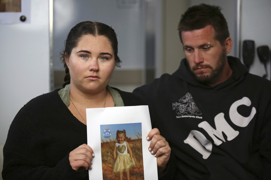 Ellie Smith, left, and her partner Jake Gliddon, display a photo of their missing daughter, Cleo, near Carnarvon in Western Australia state, Australia, Oct. 19, 2021. Cleo was rescued "alive and well" on Wednesday, Nov. 3, 2021, more than three weeks after she was suspected to have been snatched from a tent during a family camping trip on Australia's remote west coast, police said.