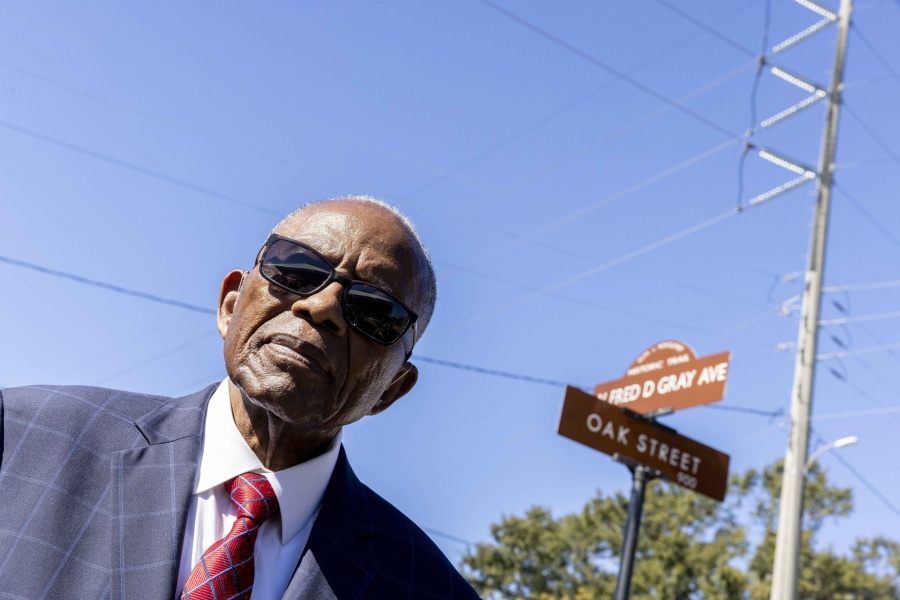 Fred Gray poses with the street renamed in his honor at the Fred D. Gray Avenue dedication ceremony, Tuesday, Oct. 26, 2021, in Montgomery, Ala. The civil-rights attorney was honored with his name on the road previously known as W. Jeff Davis Avenue.