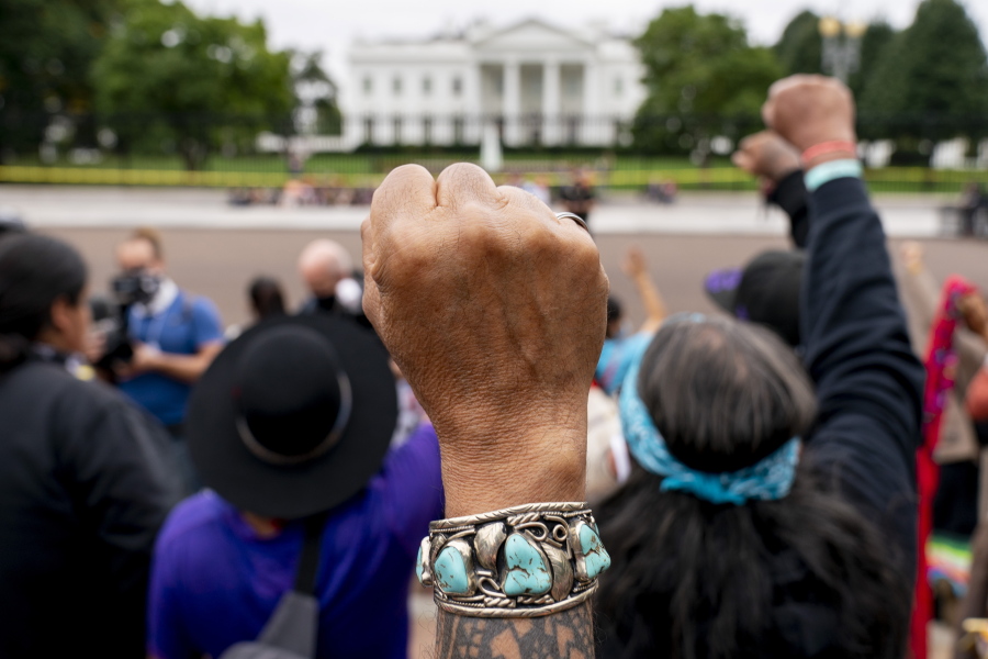 FILE - Wolf Ramerez of Houston, Texas, center, joins others with the Carrizo Comecrudo Tribe of Texas in holding up his fists as indigenous and environmental activists protest in front of the White House in Washington, Oct. 11, 2021. President Joe Biden will announce steps Monday, Nov. 15, to improve public safety and justice for Native Americans during the first tribal nations summit since 2016, the White House said.