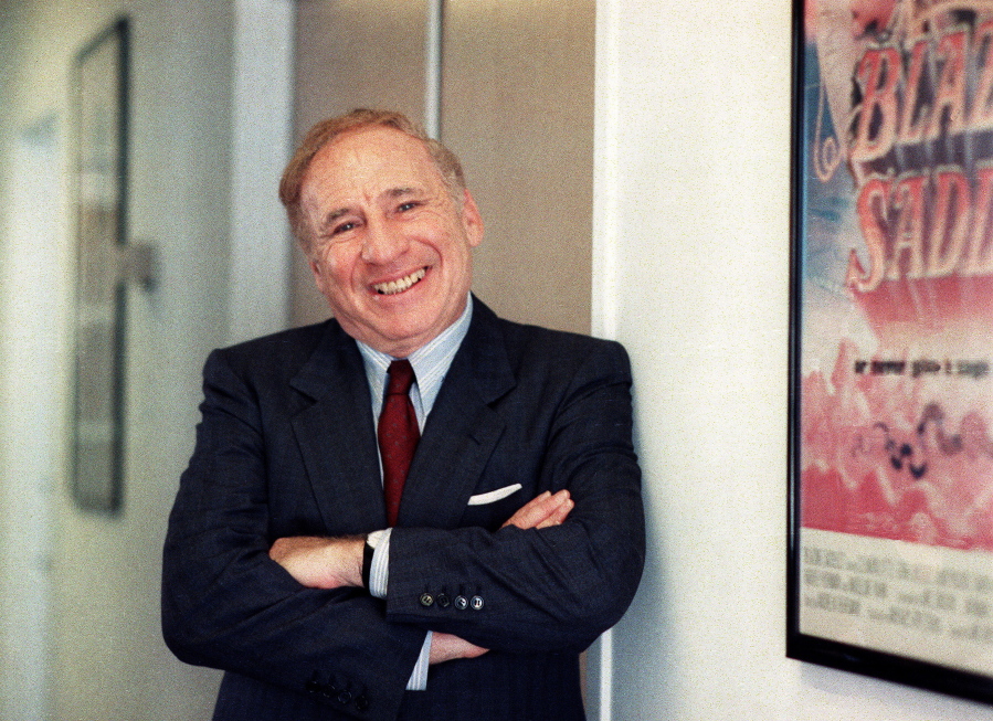 FILE - Actor-director-writer Mel Brooks poses next to a framed poster of his 1974 film "Blazing Saddles" in Los Angeles on July 23, 1991.