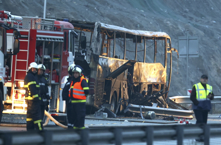 Firefighters and forensic workers inspect the scene of a bus crash which, according to authorities, killed at least 45 people on a highway near the village of Bosnek, western Bulgaria, Tuesday, Nov. 23, 2021. The bus, registered in Northern Macedonia, crashed around 2 a.m. and there were children among the victims, authorities said.