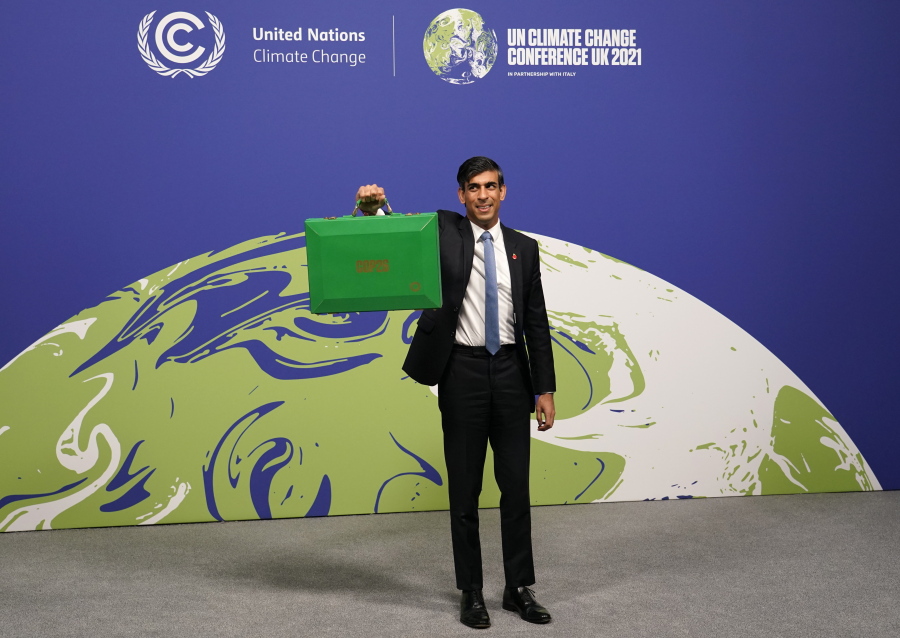 Britain's Chancellor of the Exchequer Rishi Sunak holds up a Green briefcase as he arrives for a speech at the COP26 U.N. Climate Summit in Glasgow, Scotland, Wednesday, Nov. 3, 2021. The British government plans to make the U.K. "the world's first net-zero aligned financial center" as companies and investors seek to profit from the drive to build a low-carbon economy. Sunak will lay out the government's plans during a speech Wednesday as top financial officials from around the world meet at the U.N. climate conference in Glasgow, Scotland.