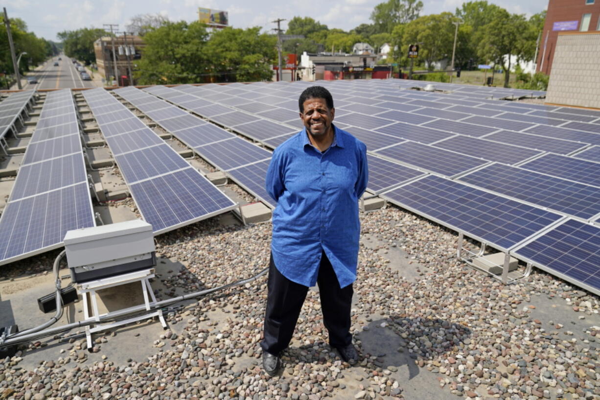 Bishop Richard Howell poses Aug. 19, 2021 beside some of the 630 solar panels on the roof of Shiloh Temple International Ministries in Minneapolis The church is one of many "community solar" providers popping up around the U.S. as surging demand for renewable energy inspires new approaches. Aug. 19, 2021, in Minneapolis.