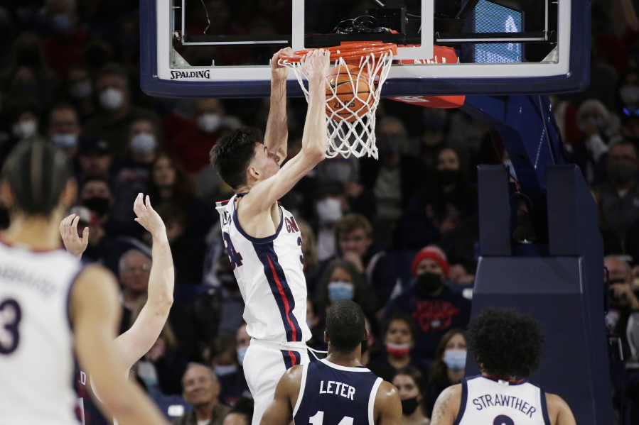 Gonzaga center Chet Holmgren, center, dunks during the first half of an NCAA college basketball game against Dixie State, Tuesday, Nov. 9, 2021, in Spokane, Wash.